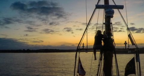 Student sitting on high sailboat lookout